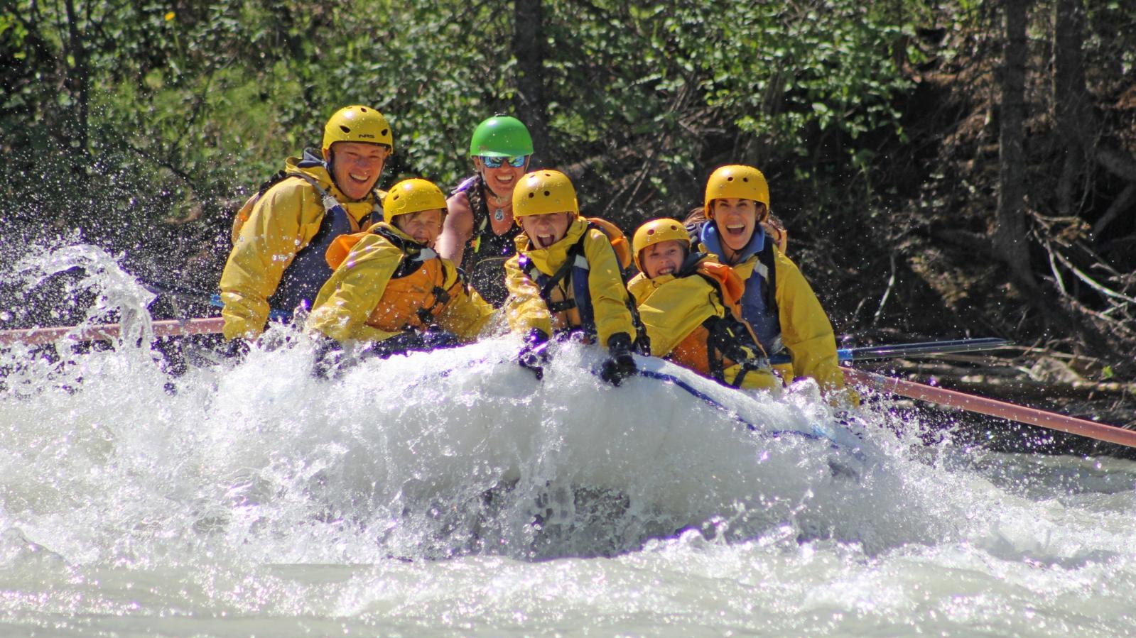 Whitewater rafters in a white raft enjoy the Kicking Horse River whitewater.