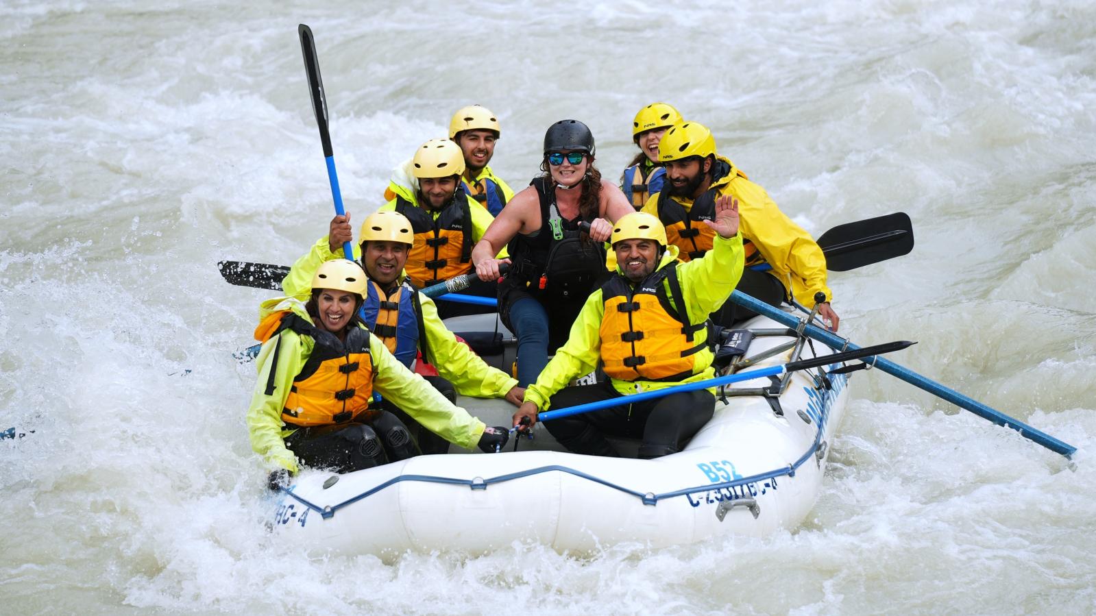 Whitewater rafters in a white raft enjoy the Kicking Horse River whitewater.