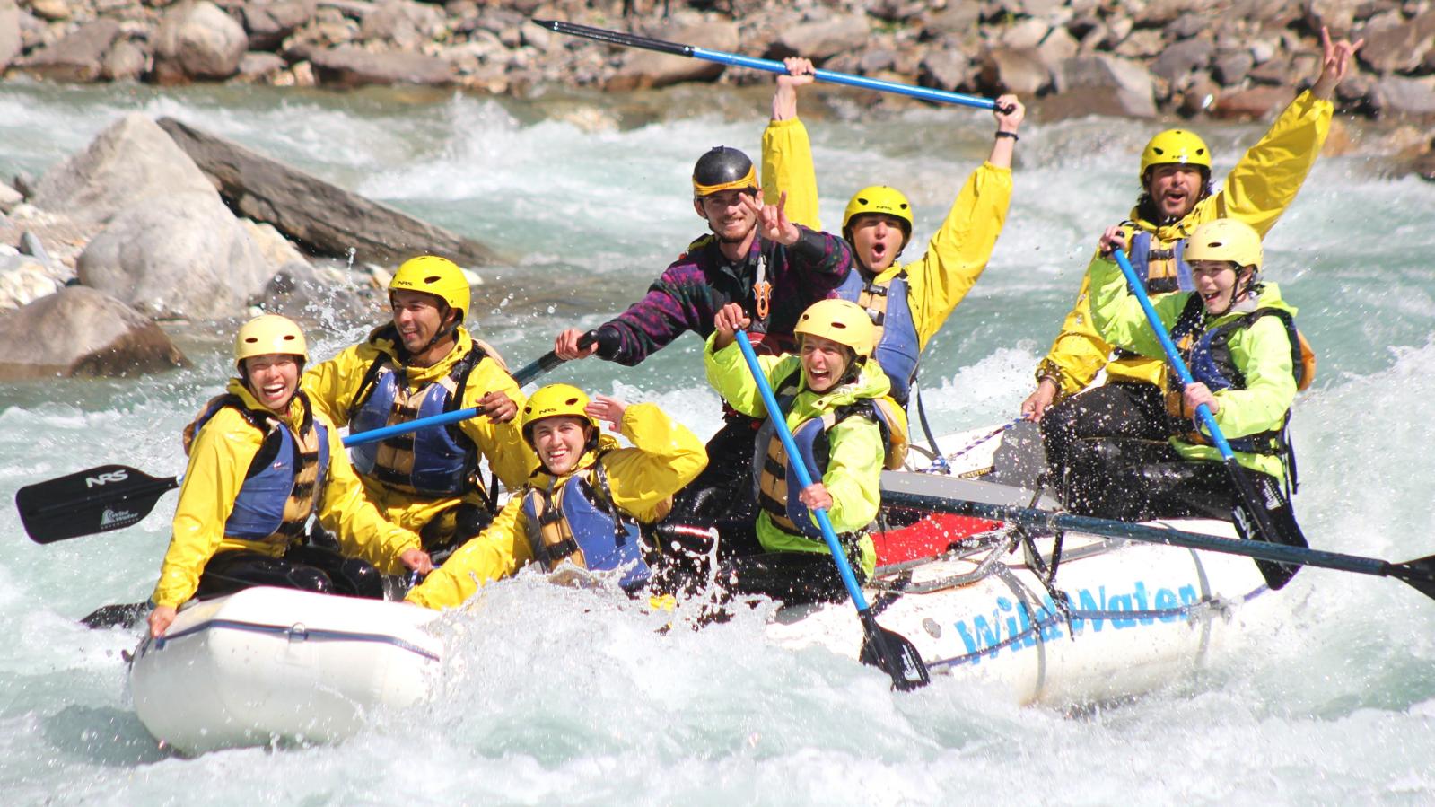 Whitewater rafters in a white raft enjoy the Kicking Horse River whitewater.