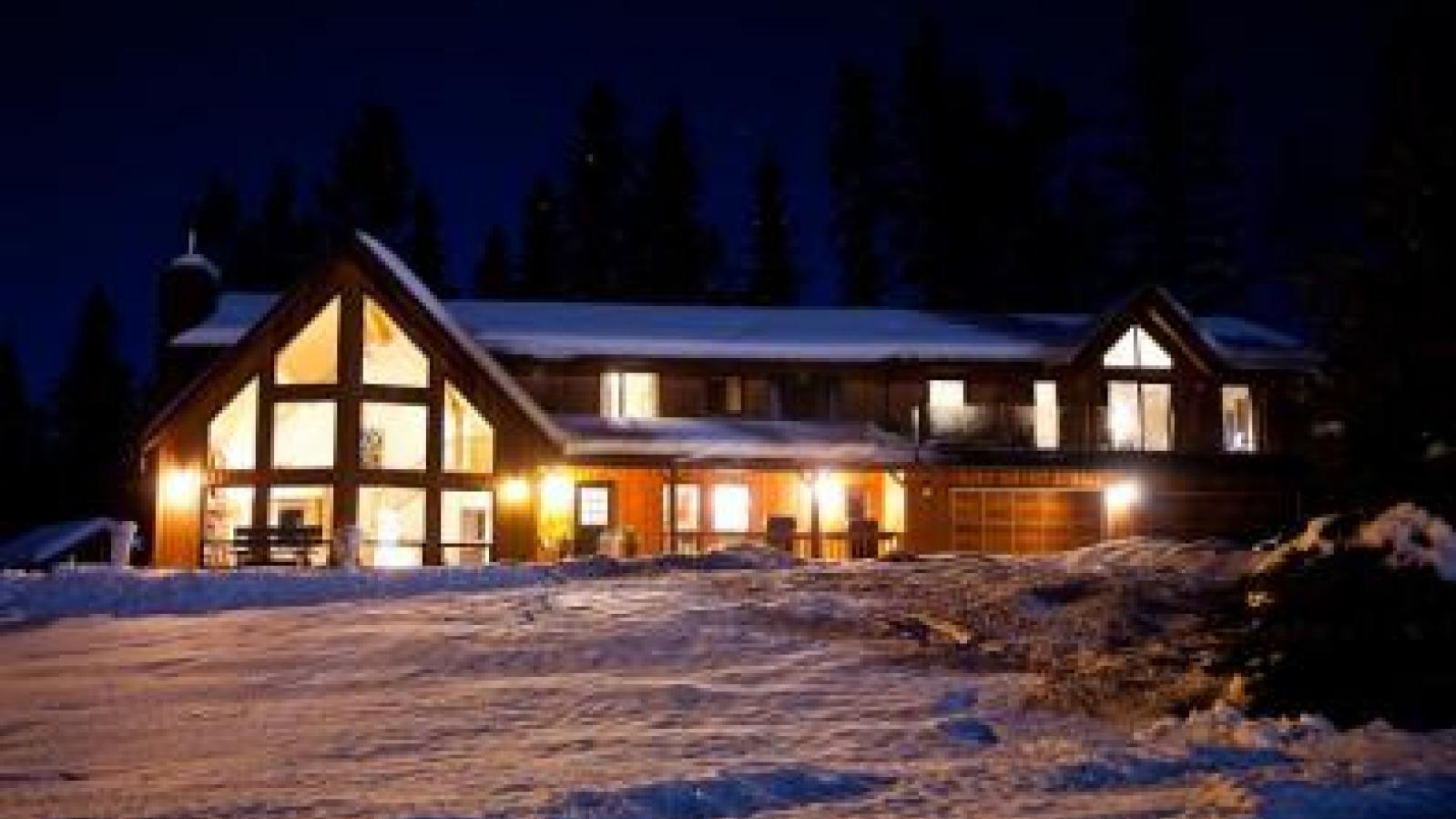 Exterior of Home Lodge Golden BC at night in winter snow.  